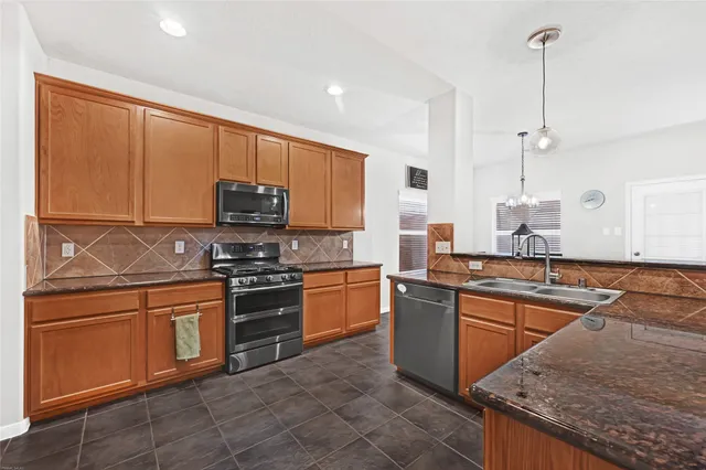 a kitchen with stainless steel appliances granite countertop a sink stove and microwave