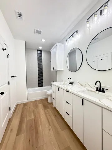 a spacious bathroom with a double vanity sink and a mirror