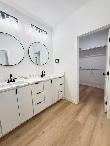 a bathroom with a double vanity sink and a mirror