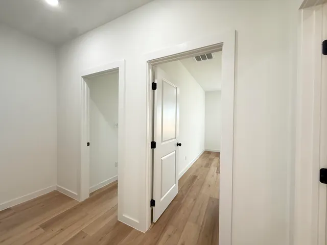 a view of a hallway with wooden floor