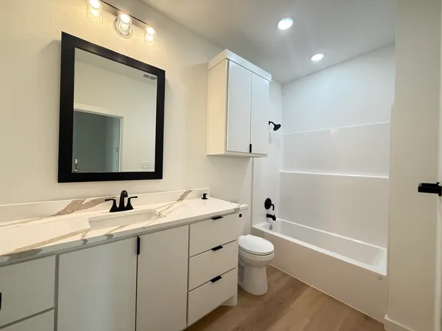 a bathroom with a toilet sink and mirror