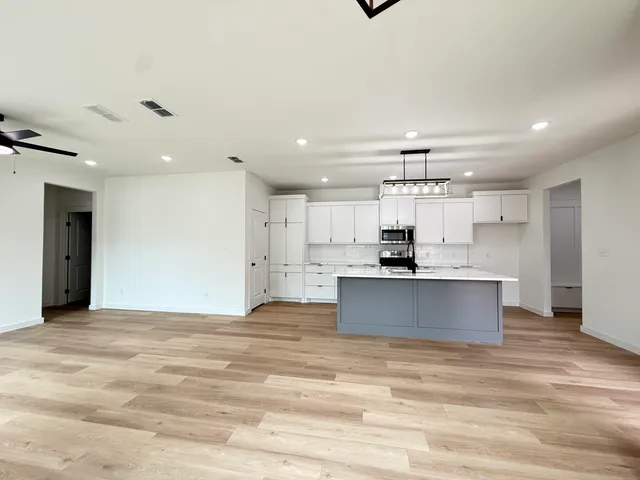 a view of kitchen with kitchen island a sink stainless steel appliances and cabinets