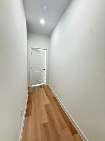 a view of a hallway with wooden floor