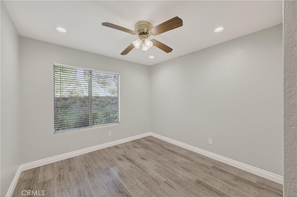 600 Central, Unit 291 Riverside, CA 92507 - Photo 14 of 35 an empty room with wooden floor chandelier fan and windows