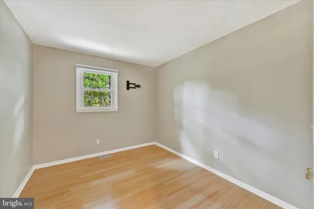 an empty room with a wooden floor and window