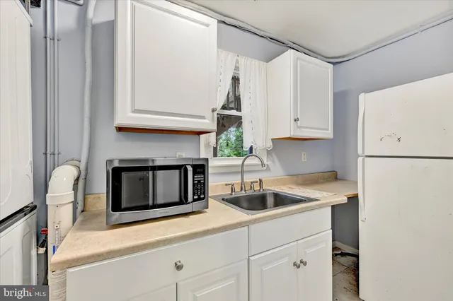 a kitchen with appliances a sink and cabinets