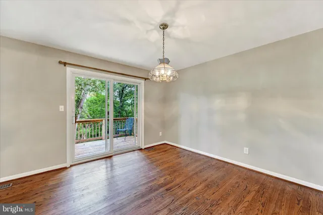 a view of a room with wooden floor fan and window