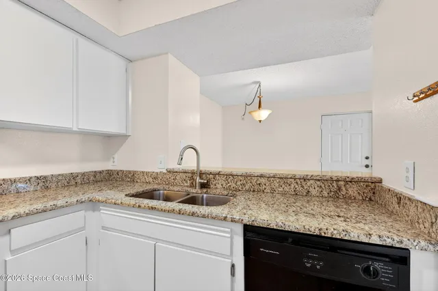 a kitchen with granite countertop a sink stove and cabinets