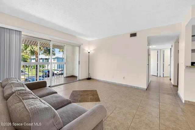 a view of kitchen with refrigerator and white cabinets