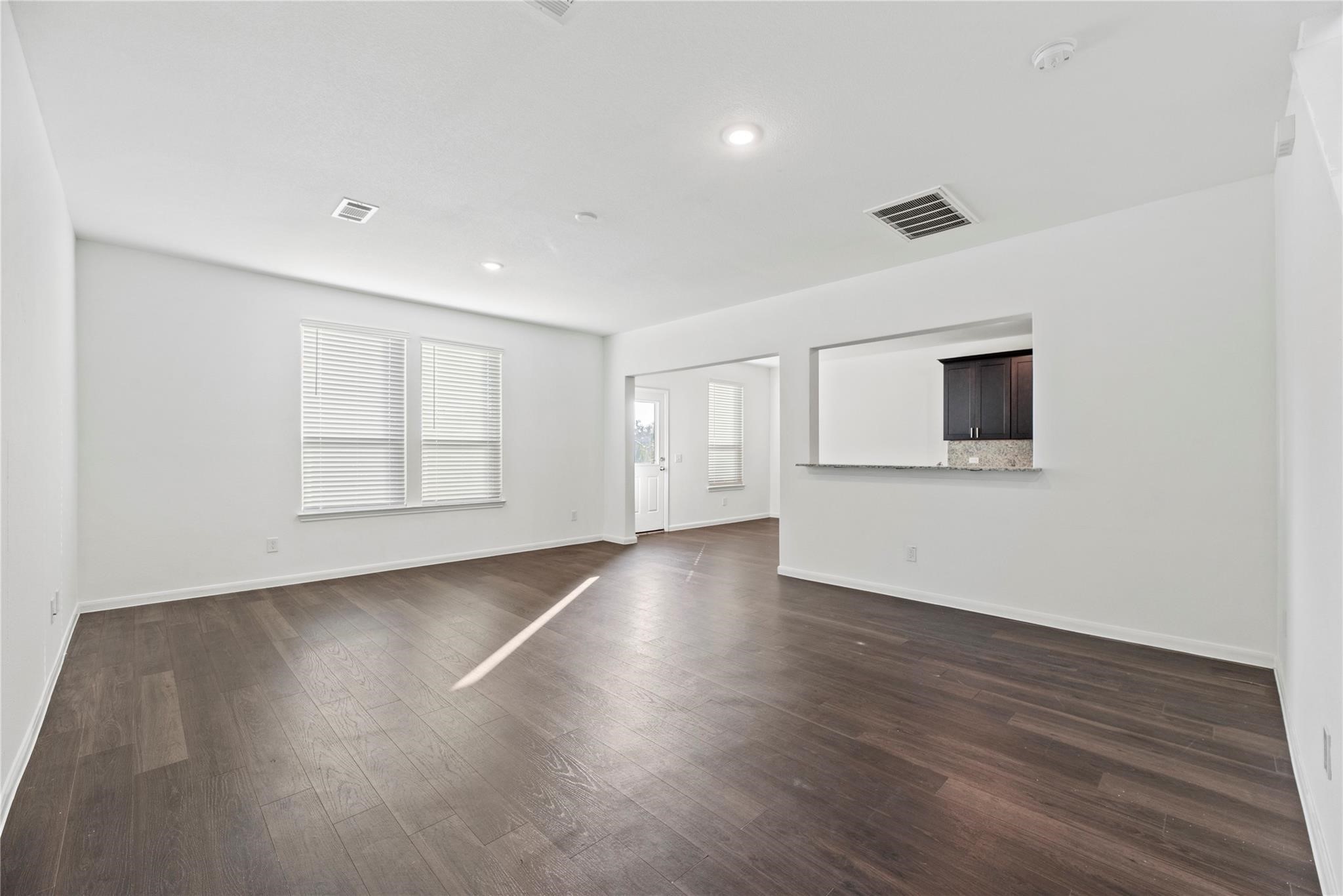 7322 Madison Cmns Lane Houston, TX 77075 - Photo 3 of 14 a view of an empty room with wooden floor and a window