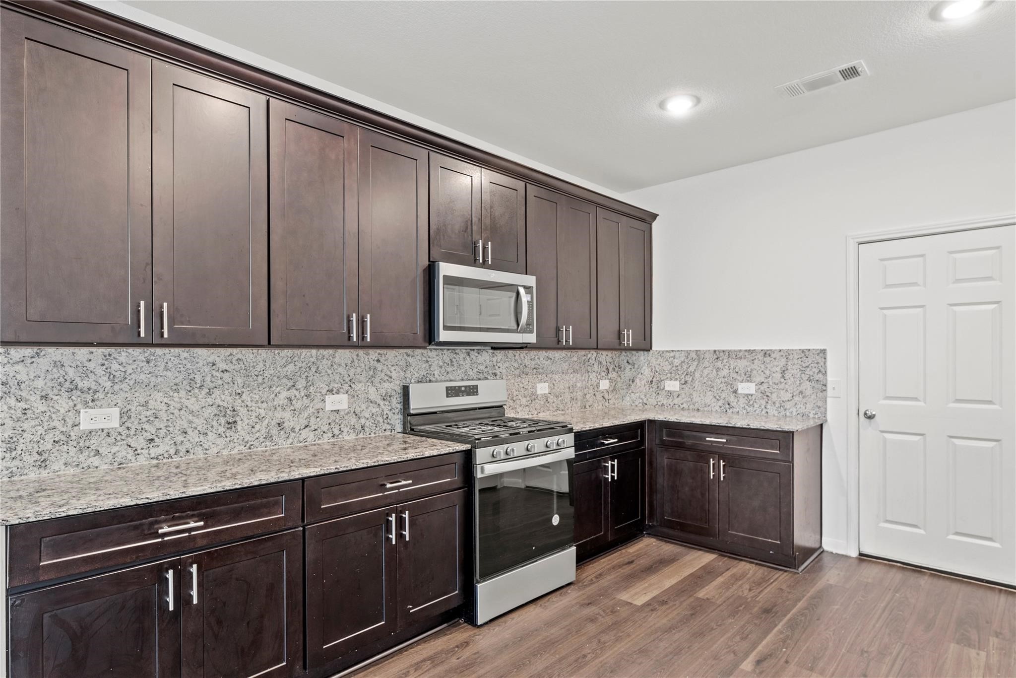 7322 Madison Cmns Lane Houston, TX 77075 - Photo 5 of 14 a kitchen with stainless steel appliances granite countertop a sink stove and cabinets