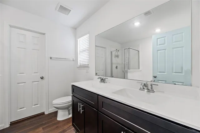 a bathroom with a sink a toilet and shower