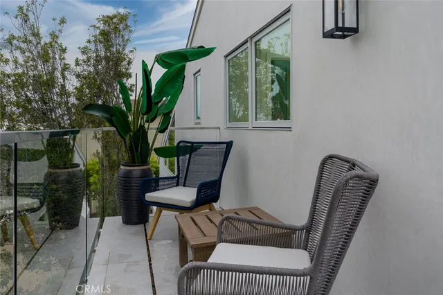 a view of a balcony with chair and potted plants