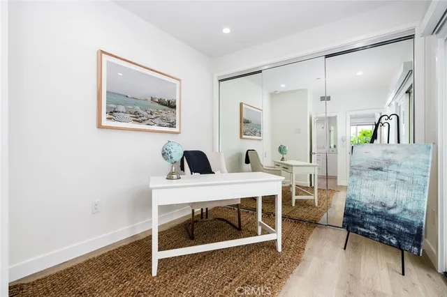 a view of a workspace room with wooden floor and white walls