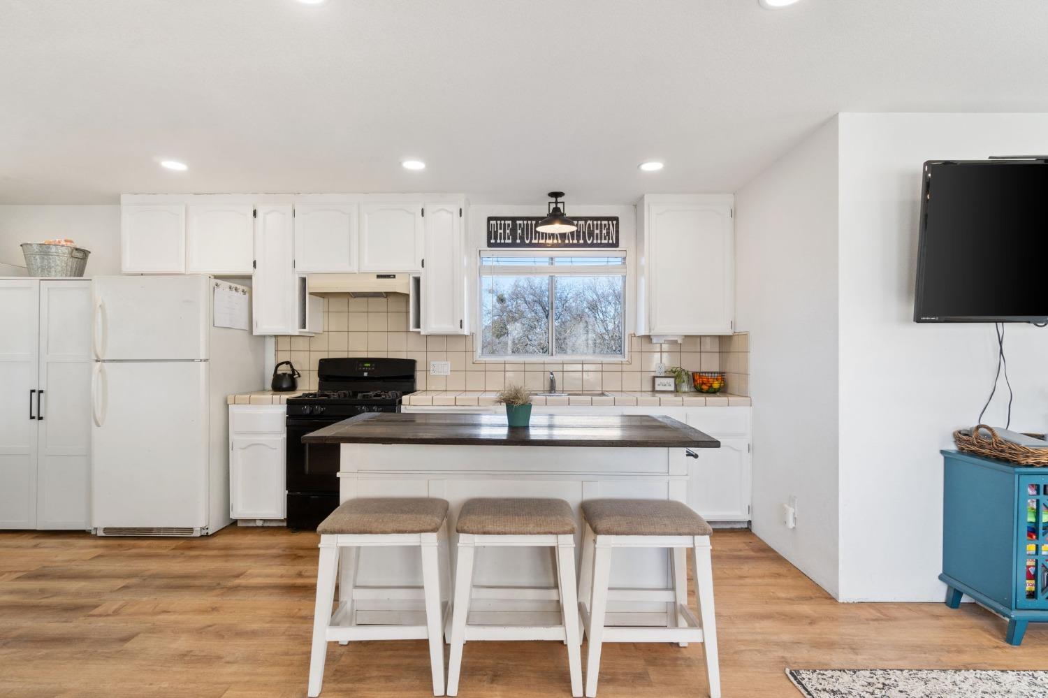 29696 Auberry Road Prather, CA 93651 - Photo 12 of 34 a kitchen with kitchen island white cabinets and stainless steel appliances