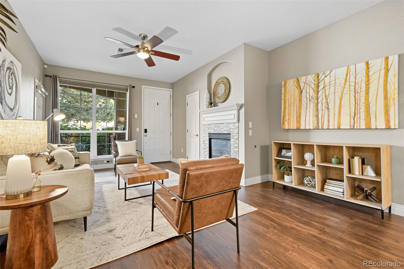 a living room with fireplace furniture and a large window