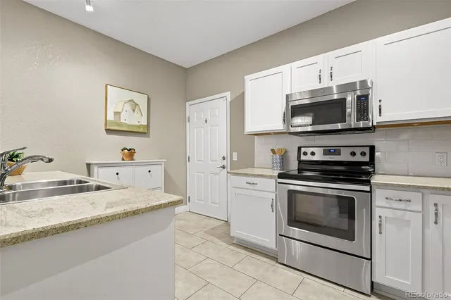 a kitchen with stainless steel appliances granite countertop a stove microwave and sink