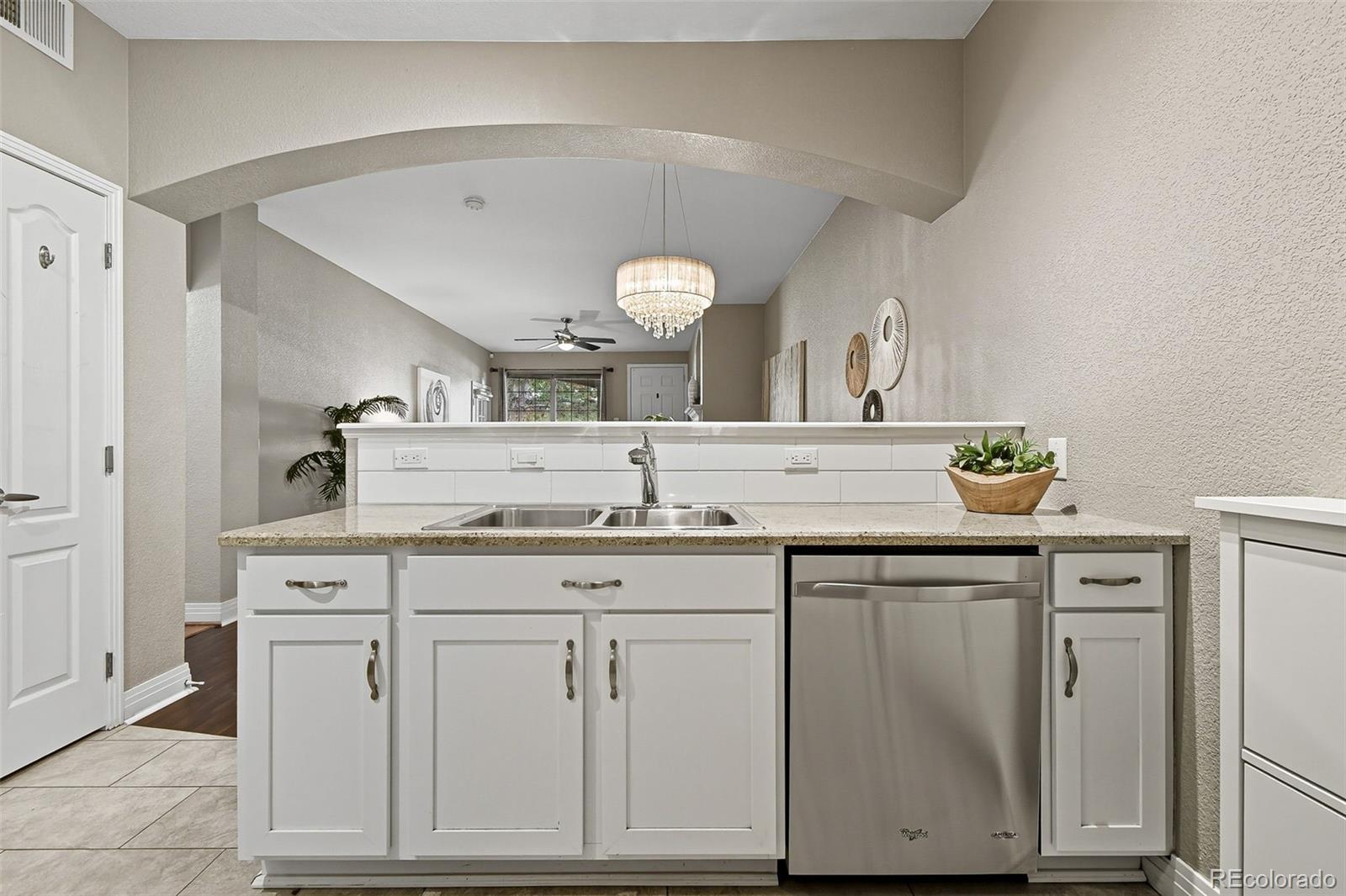 159 Quebec Street, Unit D Denver, CO 80220 - Photo 14 of 49 a sink with a granite countertop cabinets and a view of living room