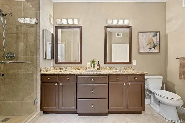a bathroom with a granite countertop toilet sink and mirror