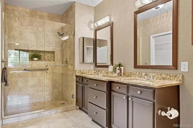 a bathroom with a granite countertop sink a mirror and a shower