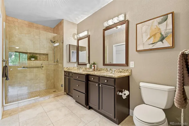 a bathroom with a granite countertop toilet sink and a shower