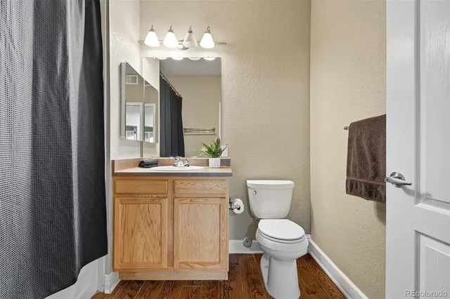 a bathroom with a toilet a sink and mirror