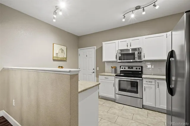 a kitchen with stainless steel appliances a refrigerator sink and stove top oven