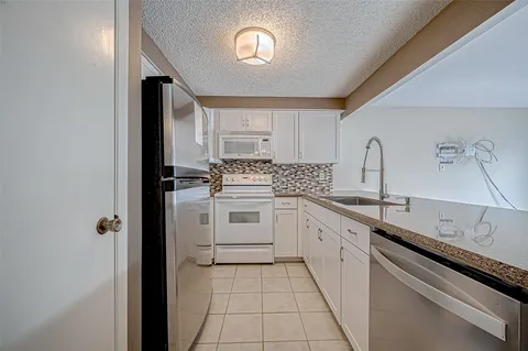 a kitchen with a sink stove and cabinets