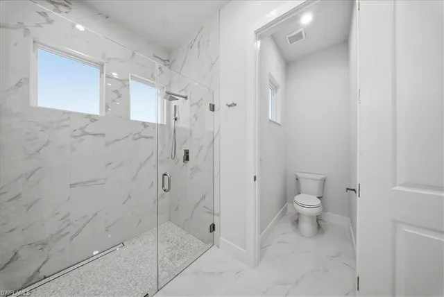 a bathroom with a toilet and a shower