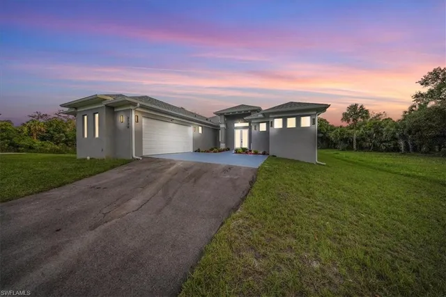 a front view of a house with yard and green space