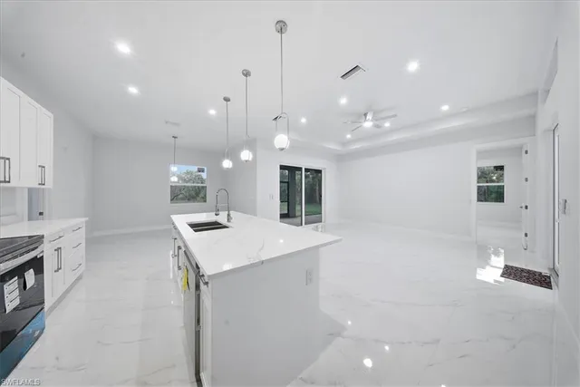 a kitchen with a sink a center island a counter space and a window