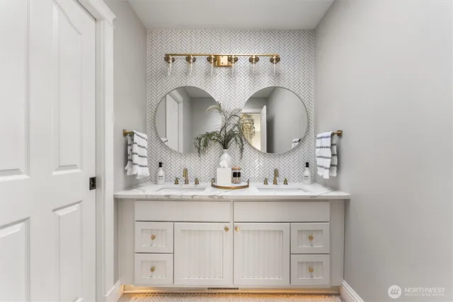 a bathroom with double vanity sink and a mirror