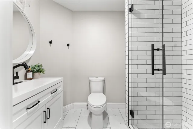 a bathroom with a toilet a sink and mirror