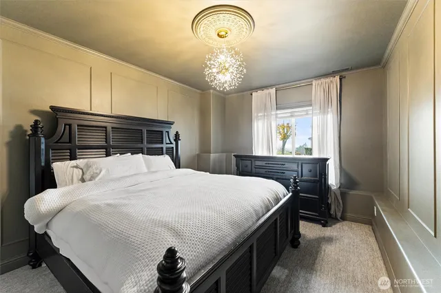a bedroom with a bed and a chandelier