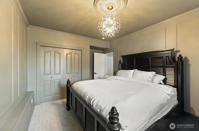 a bedroom with a large bed and a chandelier