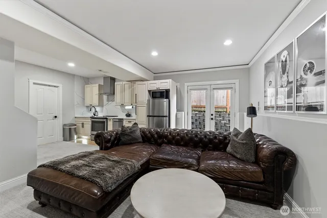 a living room with furniture wooden floor and kitchen view