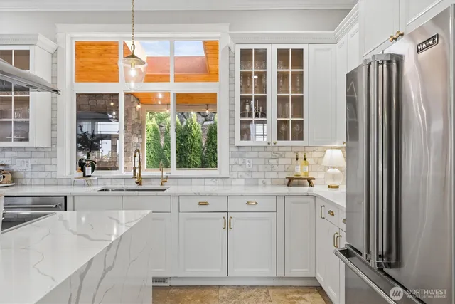 a kitchen with granite countertop a refrigerator and a sink