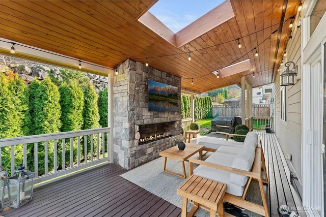 a view of a patio with table and chairs potted plants with wooden floor and floor to ceiling window