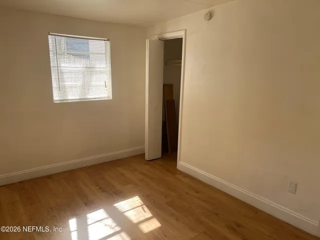 a view of a room that has wooden floor and window