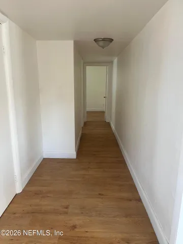 a view of a hallway with wooden floor
