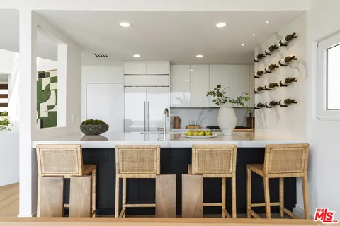 a kitchen with kitchen island stainless steel appliances a stove refrigerator sink and cabinets