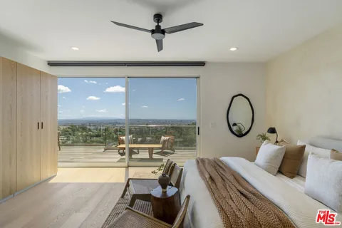 a living room with a bed furniture and a large window