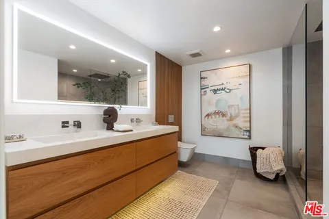 a spacious bathroom with a double vanity sink toilet and shower
