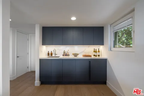 a kitchen with granite countertop white cabinets and window