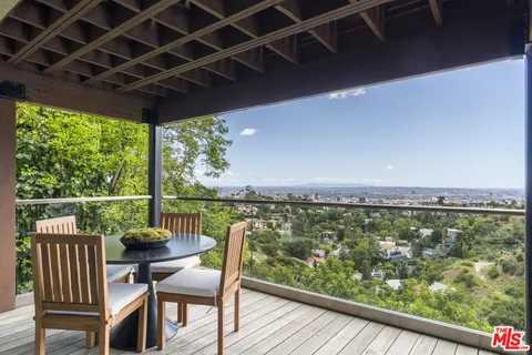 a view of a chairs and table in the balcony