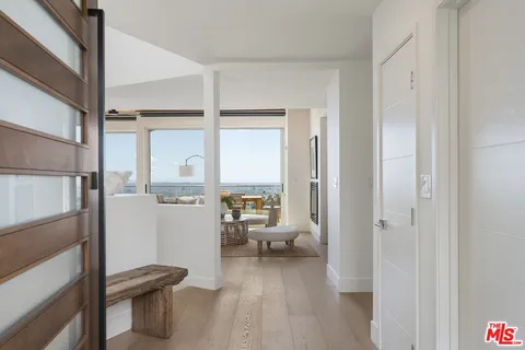 a view of a hallway with bathroom and wooden floor