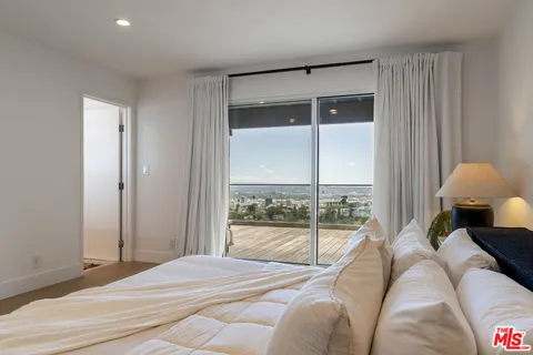 a bed sitting in a bedroom next to a window