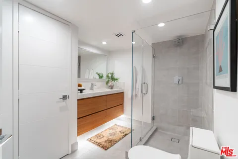 a bathroom with a shower sink and vanity