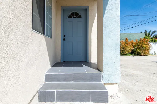 a view of staircase with white walls and a potted plant