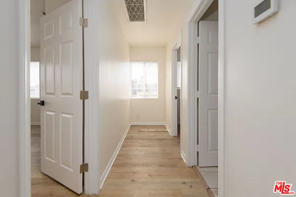 a view of a hallway with wooden floor and closet
